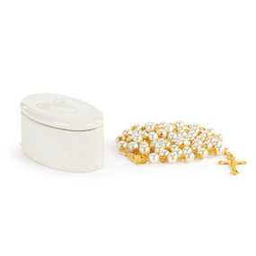 An oval white ceramic trinket box next to a gold and white bead rosary.