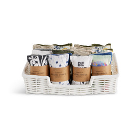 A white woven displayer basket filled with an assortment of byDesign kitchen sponges.