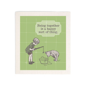 A green biodegradable dish cloth that says "Being together is a happy sort of thing" with an image of Pooh and Christopher Robin fishing in a tub.