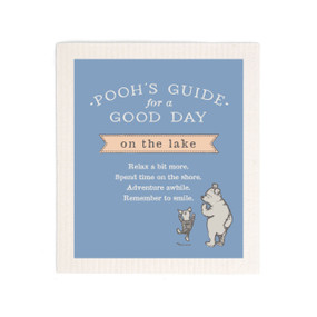 A blue biodegradable dish cloth that says "Pooh's Guide for a Good Day on the Lake" with an image of Pooh and Piglet.
