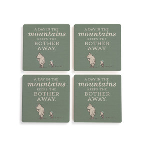 A set of four green square ceramic coasters that say "A Day in the mountains Keeps the Bother Away" with an image of Pooh and Piglet.