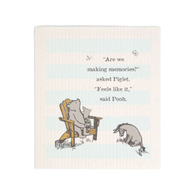 A light blue and white striped biodegradable dish cloth that says "Are we making memories?" asked Piglet. "Feels like it," said Pooh. There is an image of Pooh, Piglet and Eeyore sitting together.