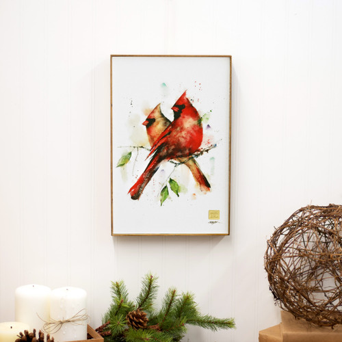 A light wood framed watercolor image of a pair of cardinals perched on a branch, displayed hanging on the wall.