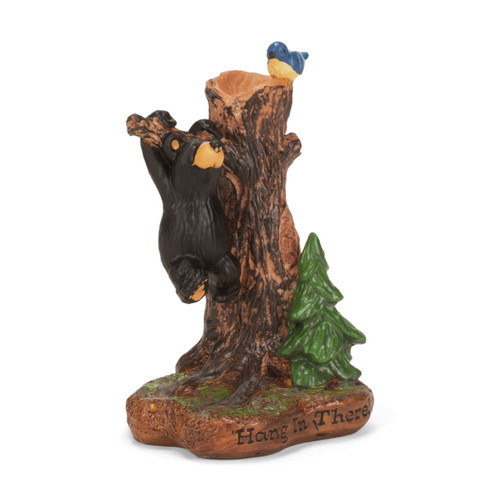A mini figurine of a tree trunk with a small black bear hanging off of a branch with a bluebird perched at the top. The figurine says "Hang in There!" on the base, displayed angled to the right.