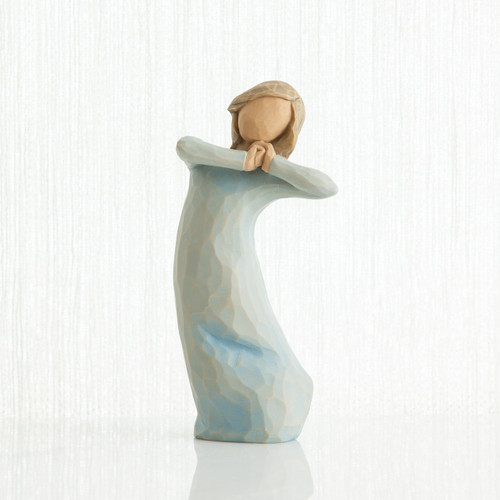 Small brown hair girl figurine wearing light blue dress and hands up to her face