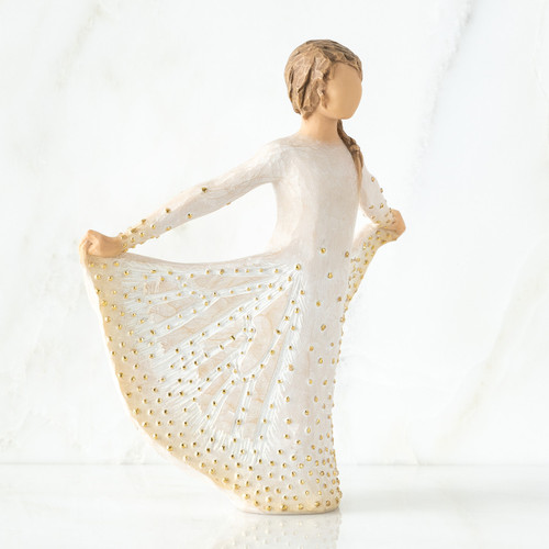Brunette girl figurine in white dress with gold polka dots holding it up