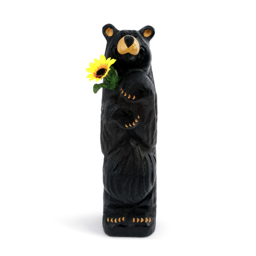 Carved standing black bear holding a sunflower