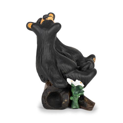 Right profile view showing a figurine of two black bears sitting on a fallen log looking at each other with their noses almost touching.