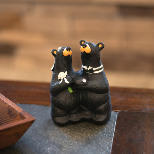 A carved figurine of two newlywed black bears, displayed on a desk.