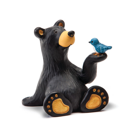 A small figurine of a black bear holding a small blue bird on its paw.