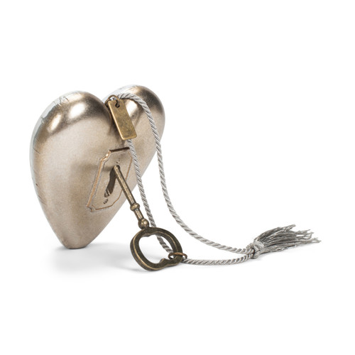 Back view of a heart shaped sculpture with a watercolor blue and green leaf image and says "Sisters A bond that's strong and lifelong" with a metal key and silver tassel attached.