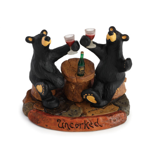 Two black bear figurines sitting on rock holding up red wine glasses - 'uncorked' carved in