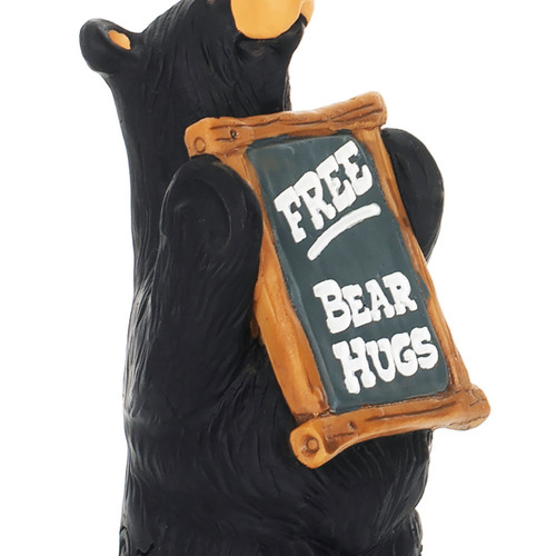 Detail view of the sign on a figurine of a standing black bear holding a "Free Bear Hugs" sign.