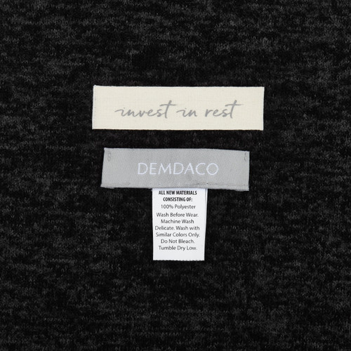 Black cloth with white tag 'invest in rest' and 'DEMDACO' in grey