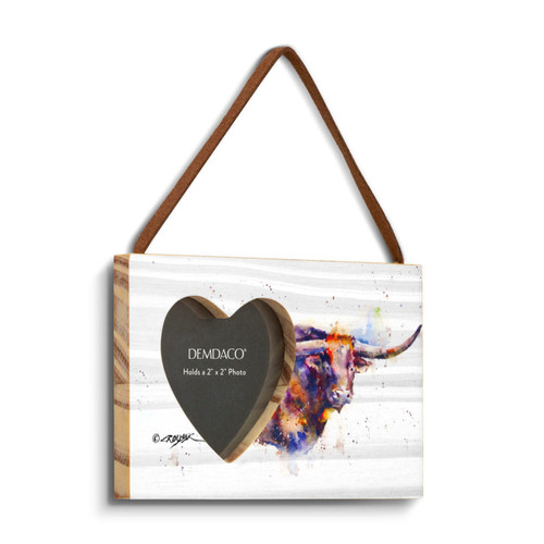 A rectangular wood hanging frame with a heart shaped 2 inch photo opening next to a watercolor image of a longhorn, displayed angled to the right.