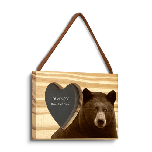 A rectangular wood hanging ornament with a heart shaped 2 inch photo opening next to an image of a bear, displayed angled to the right.