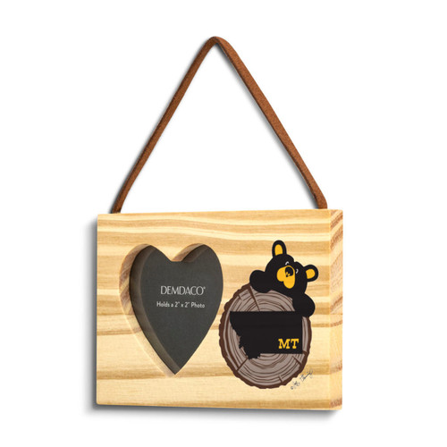 A rectangular wood hanging ornament with a 2x2 inch heart shaped photo opening next to an image of a black bear peeking over a wood stump with Montana on it, displayed angled to the left.
