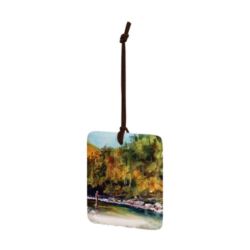 A square hanging ornament with a watercolor image of a fly fisher in the river, displayed angled to the left.