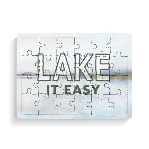 A 24 piece postcard puzzle that says "Lake it Easy" on a light lake scene background.