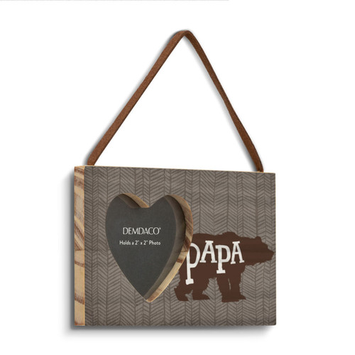 A hanging rectangular brown wood frame with a 2 inch heart shaped opening for a photo next to a bear silhouette that says "Papa" angled to the right.