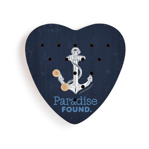 A dark blue heart shaped wood peg game with a white anchor and the saying "Paradise Found" shown with two wood pegs in the holes.