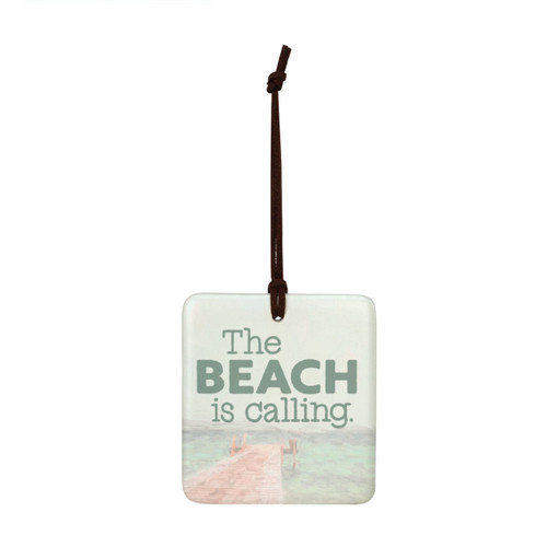 A square tile hanging ornament with a lake pier scene that says "The Beach is Calling".
