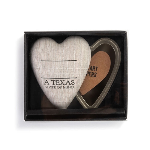 A heart shaped container with a wood grain lid that says "A Texas State of Mind" under two black lines, with the lid offset to the base, in a packaging box.