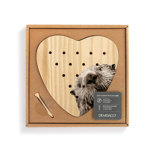 A heart shaped wood peg game that has the image of an otter, shown in a packaging box with a product information tag.