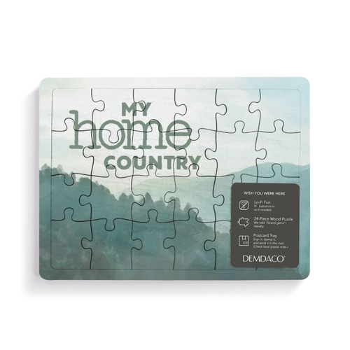 A 24 piece postcard puzzle that says "My home country" on a green mountain background with a product information tag attached.
