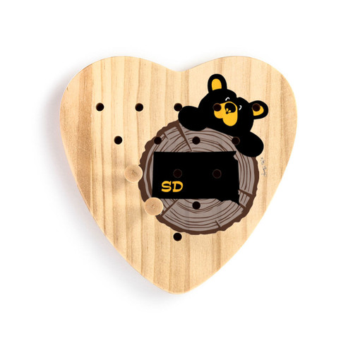 Heart shaped wood peg game with a black bear peeking over a wood stump with South Dakota on it, shown with two wood pegs in the game.
