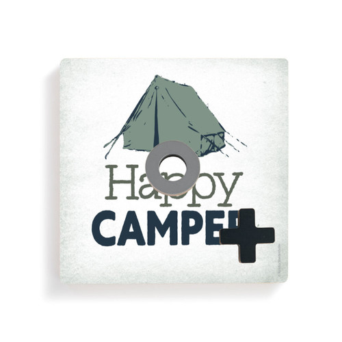 A white square board with a green tent and the saying "Happy Camper" for tic tac toe with a gray O and black X on top.