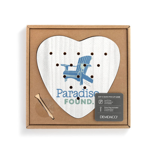 A white heart shaped wood peg game with a blue Adirondack chair and the saying "Paradise Found" inside a cardboard packaging box with a product information tag.