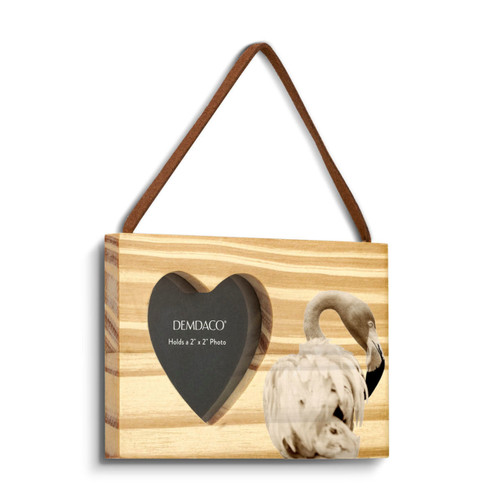 A rectangular wood hanging ornament with a heart shaped 2 inch photo opening next to an image of a flamingo, displayed angled to the right.