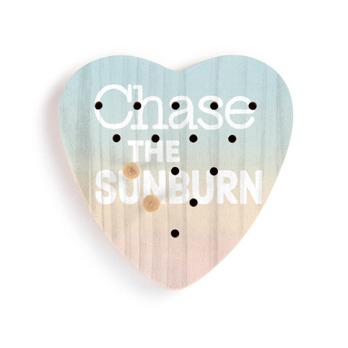 A sunset colored heart shaped wood peg game that says "Chase the Sunburn", displayed with two pegs in the game.