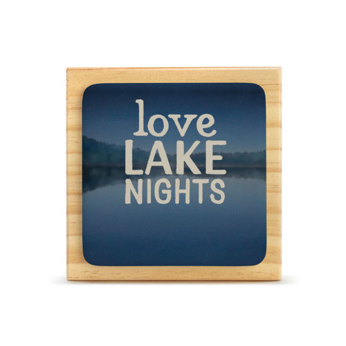 A square wood plaque that has a dark blue tile with a lake scene that says "Love Lake Nights".