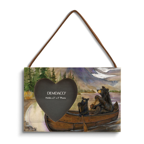 A rectangular wood hanging frame with a 2x2 inch heart shaped photo opening and has a painted image of two black bears rowing a canoe.