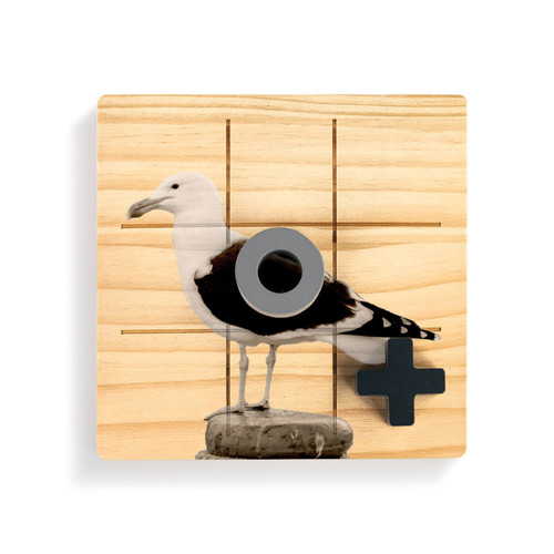 A square wood board for tic tac toe with an image of a sea gull, shown with a gray O and black X on top.
