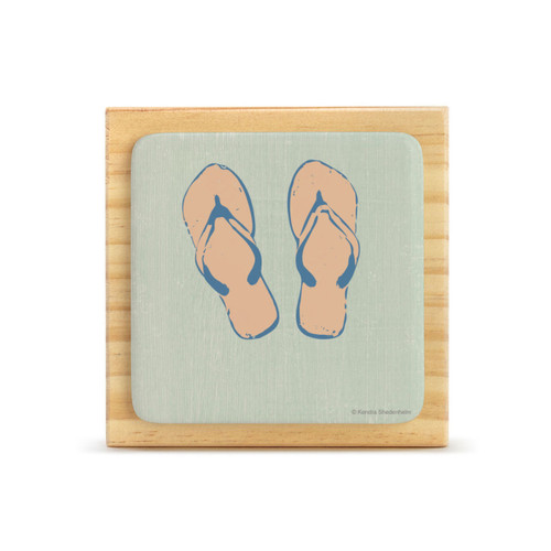 A square wood plaque with an attached tile that has a set of flip flops on a light green background.