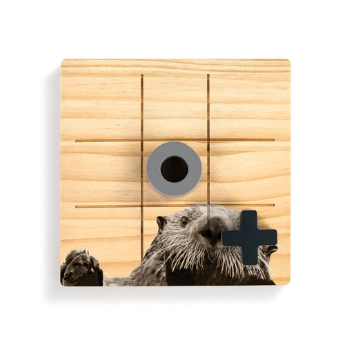 A square wood board for tic tac toe with an image of an otter, shown with a gray O and black X on top.