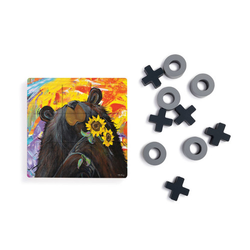 A square wood tic tac toe board with a painted image of a black bear with sunflowers, next to a set of X's and O's in gray and black.