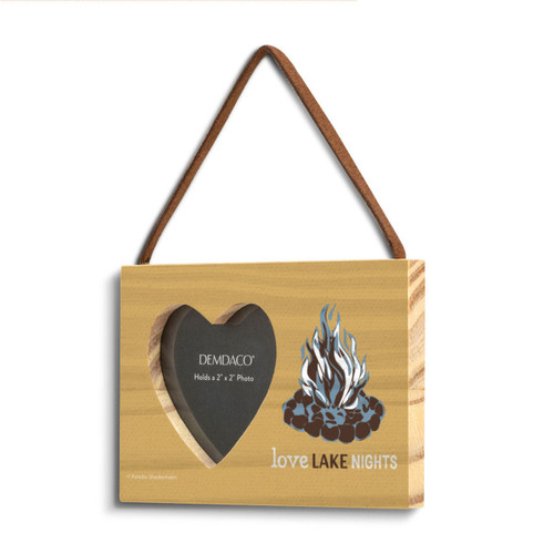 A dark yellow rectangular hanging wood frame with a 2 inch heart shaped opening for a photo next to the image of a bonfire and the saying "Love Lake Nights" shown angled to the left.