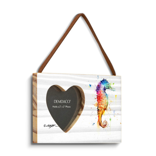 A rectangular wood hanging frame with a heart shaped 2 inch photo opening next to a watercolor image of a seahorse, displayed angled to the right.