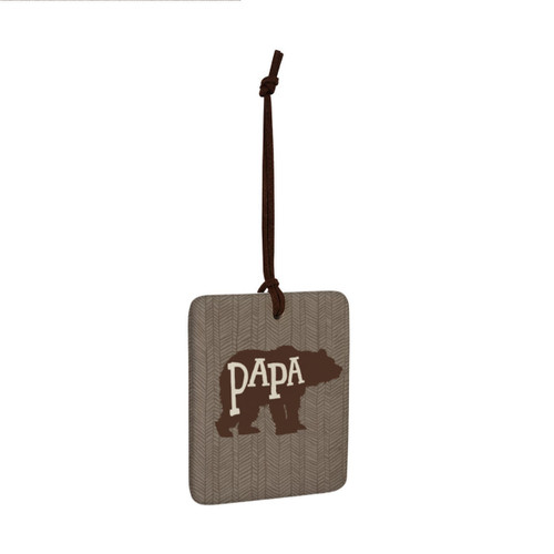 A square hanging ornament with a bear silhouette that says "Papa" on a brown geometric background angled to the right.
