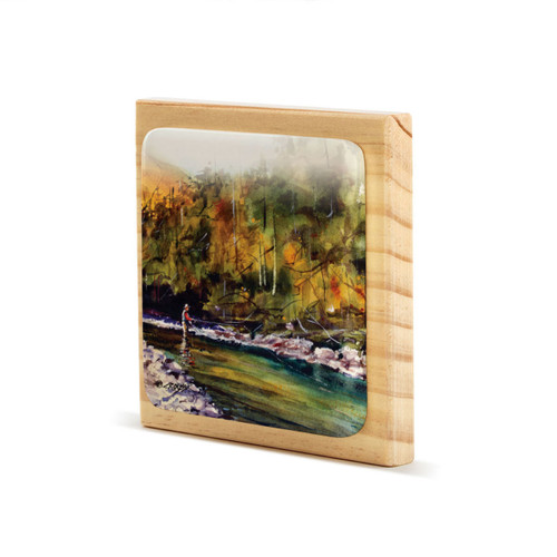 A square wood plaque angled to the left with a tile attached that has a watercolor image of a fly fisher in a river.