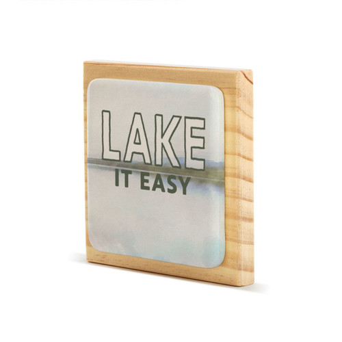 A square wood plaque that has a tile with a lake scene and says "Lake It Easy", displayed angled to the left.