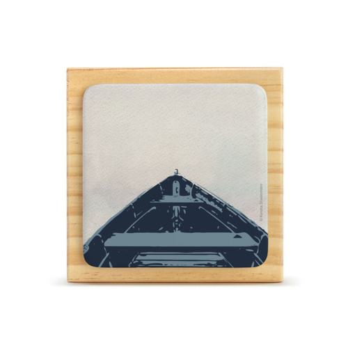 A square wood plaque with a cream tile attached that has the image of looking over the bow of a boat.