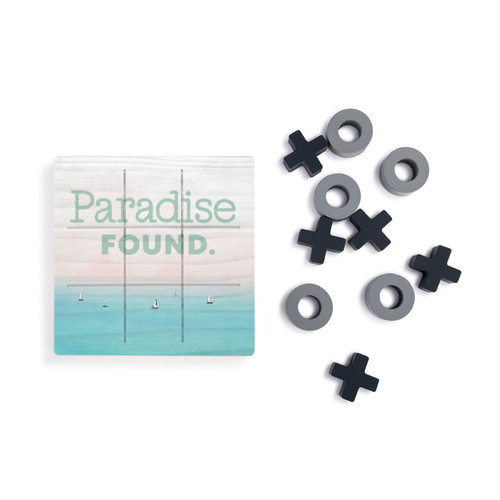 A square wood board for tic tac toe with a lake scene that says "Paradise Found", next to a set of X's and O's in gray and black.