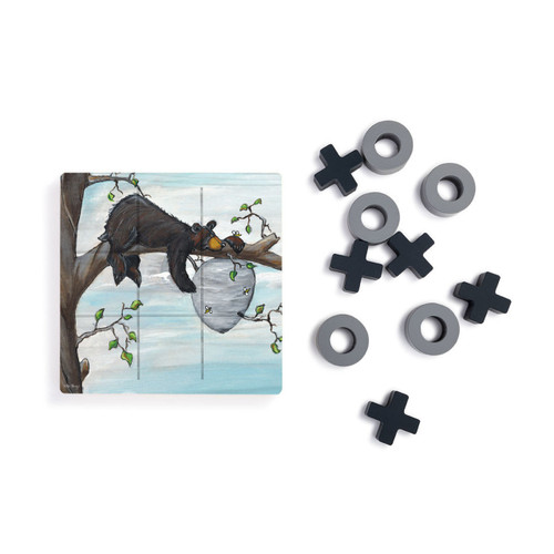 A square wood tic tac toe board with a painted image of a black bear on a tree branch next to a beehive, next to a set of X's and O's in gray and black.