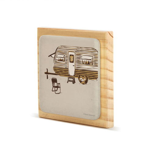 A square wood plaque with a tile attached that has an image of a brown and white camper on a tan background angled to the left.
