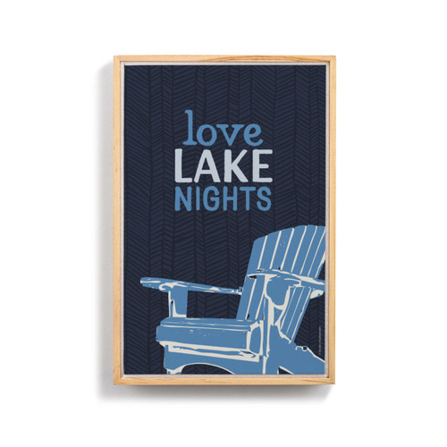 A graphic art image of a blue Adirondack chair with "Love Lake Night" written above it on a dark blue background. The image is in a light wood frame.
